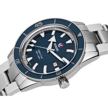 Experience the allure of the Rado Captain Cook 42mm watch. Featuring a captivating blue dial, precise automatic movement, and a durable ceramic and stainless steel case, this timepiece embodies nautical elegance. Its stainless steel bracelet adds a touch 
