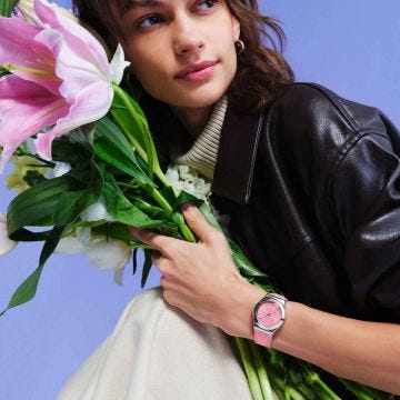 Photo of the Swatch Pink Petal Promise 33mm pink floral dial quartz watch with pink leather strap, model YLS234